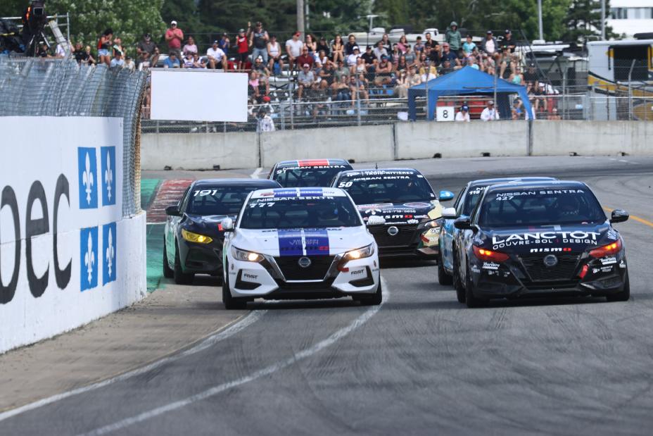 Several Nissan Sentra race cars racing on the Trois-Rivieres track for the Grand Prix de Trois-Rivieres in 2024 with spectators in the background