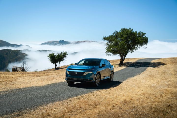 The 2026 Nissan Murano driving along a mountain path with trees behind.