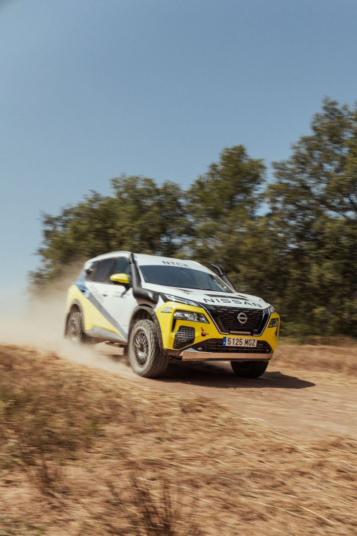 Fahraufnahme des Nissan X‑Trail Rennwagens während der Baja Aragon Rallye 2024, das Auto fährt einen sandigen Abhang hinunter und wirbelt viel Staub auf