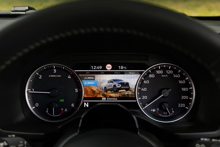 2026 Nissan Navara PRO-4X finished in Boulder Grey featuring the terrain selection screen with ROCK mode, warm-toned ground texture and dismiss message.
