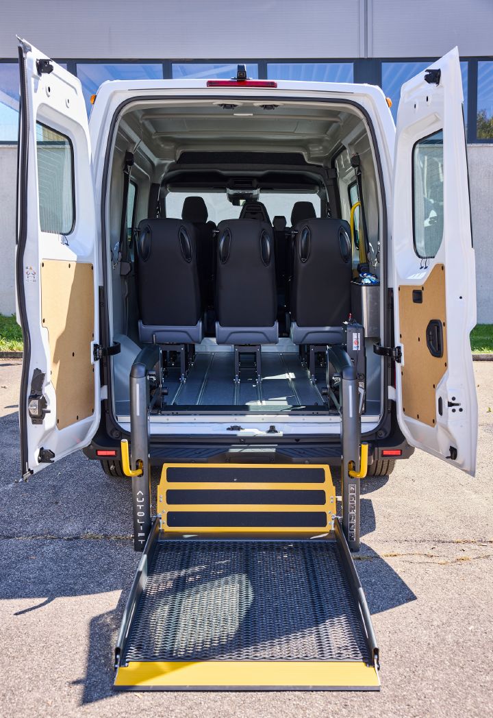 Blick auf des Heck des Nissan Interstar-e mit MobiTEC Ausbau mit herabgelassenem Rollstuhllift und Blick auf die Rückseite der dritten Sitzreihe