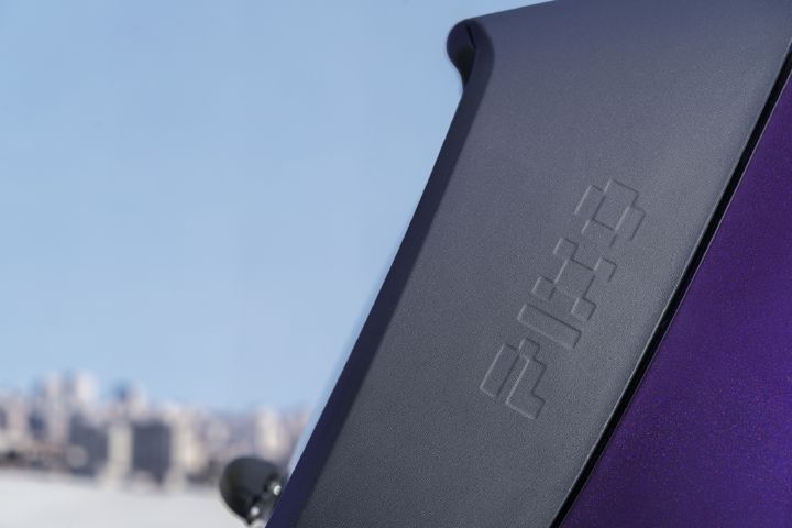 Close-up of a textured black exterior trim element on the Nissan PIXO, featuring an embossed “PIXO” lettering.