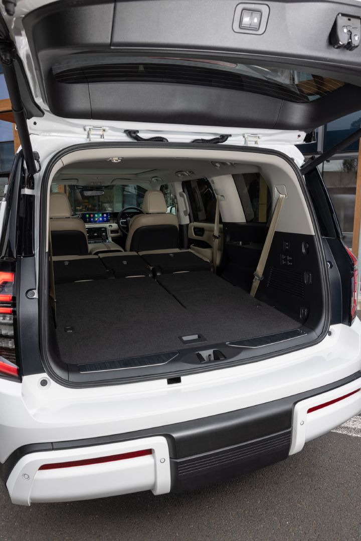 2026 Nissan Y63 Patrol finished in white, rear cargo area shown with the tailgate open and second- and third-row seats folded flat to create an extended load floor.