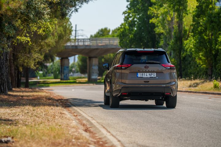 Heckansicht auf den Nissan X‑Trail, der auf einer Straße fährt