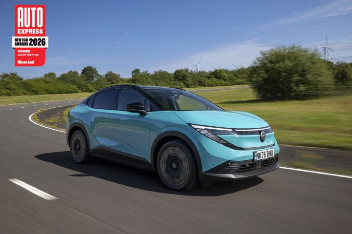 A teal-coloured Nissan LEAF driving along a country road with wind turbines in the background, with an Auto Express logo in the top left corner