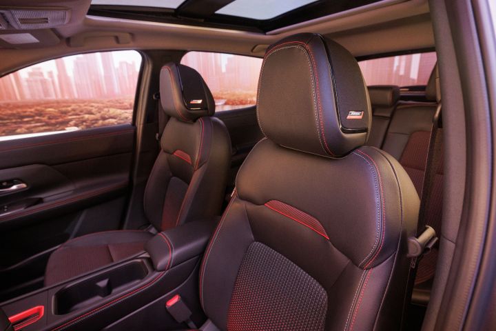 The black leather driver and passenger seats featuring red stitching in the 2025 Nissan Kicks.