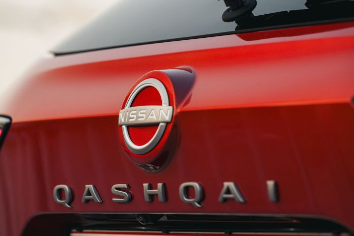 Detailansicht Nissan Logo und Qashqai Schriftzug am Heck des Nissan Qashqai in Fuji Sunset Red