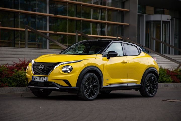 Żółty Nissan Juke stojący bokiem na tle budynku