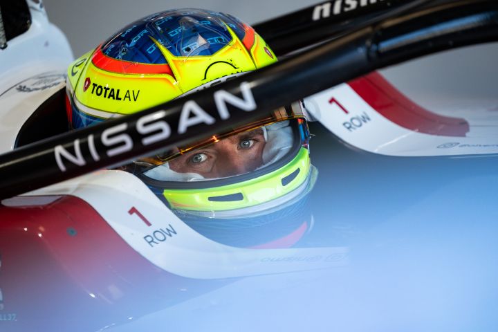 Oliver Rowland saß mit seinem gelb-blauen Helm und hochgeklapptem Visier im Nissan Formula E Rennwagen mit der Startnummer 1 in der Teamgarage.