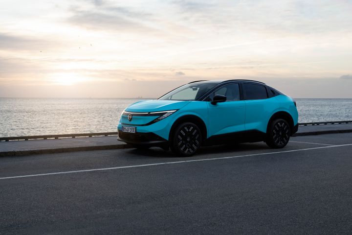 Nissan LEAF driving along a waterfront road with beautiful skyline