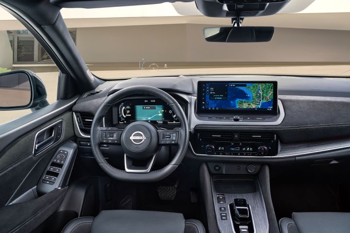 Interieur des Nissan Qashqai, Blick vom Fahrersitz auf das Cockpit mit Lenkrad, Fahrerinformations-Display sowie Infotainment-Bildschirm