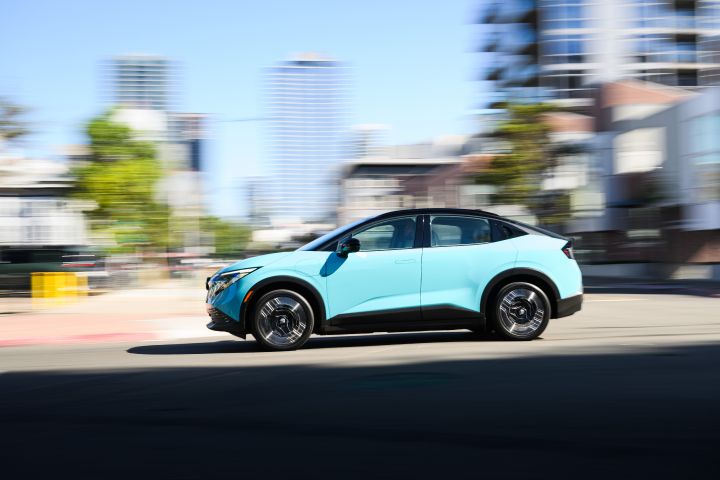 Left profile view of the 2026 Nissan LEAF driving on a city street.
