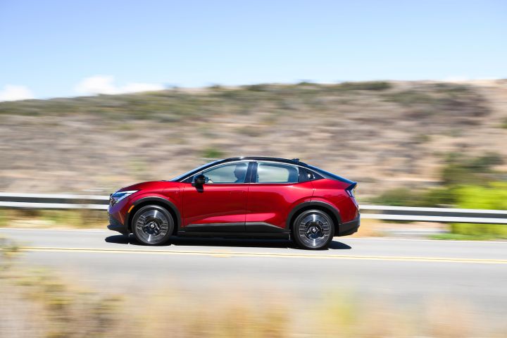 Left profile view of the 2026 Nissan LEAF driving along an arid highway.