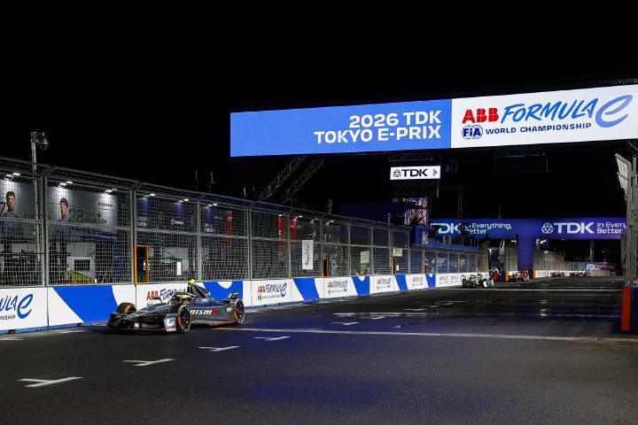Oliver Rowland überquert im Nissan Formula E Rennwagen mit der Startnummer 1 die Ziellinie beim E-Prix von Tokio, während auf der digitalen Anzeigetafel über der Strecke „2026 TDK Tokyo E-Prix“ zu lesen ist.
