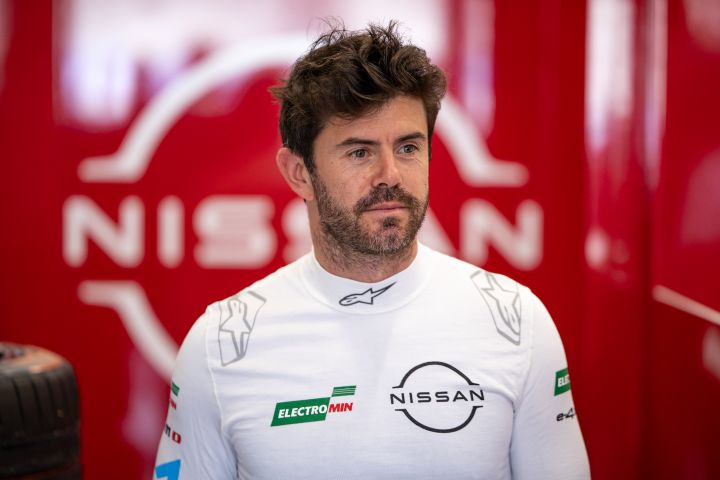 Norman Nato in seinem weißen Unterhemd in der Teamgarage, hinter ihm ist auf rotem Hintergrund teilweise das Nissan-Logo zu sehen.