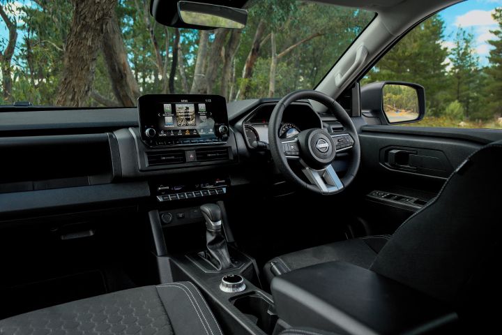 2026 Nissan Navara ST dual cab ute finished in Summit Silver displayed in a wide interior view with the dashboard, touchscreen, steering wheel and centre console.