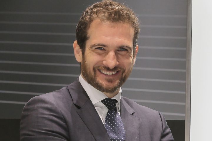 Tommaso Volpe posing for a photo in a suit.