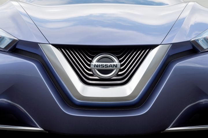 The Nissan emblem displayed prominently on the front of a blue vehicle's grille