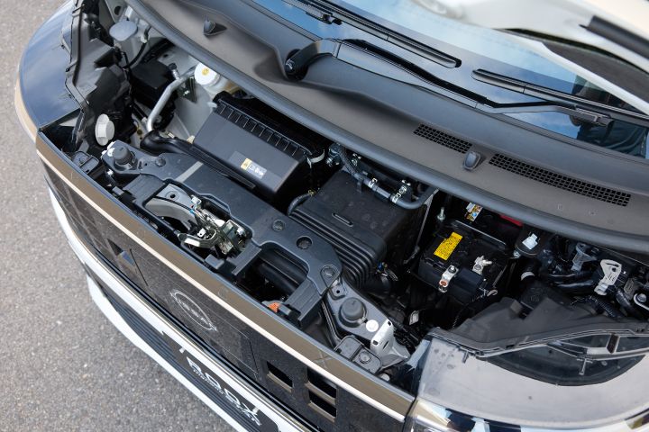 The hood of the new Nissan Roox kei car is open, showing the engine compartment from above. The engine, battery, and other mechanical components are visible.