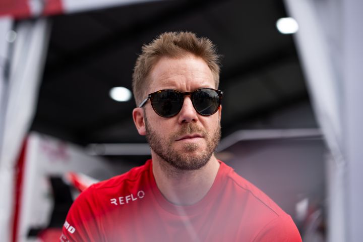 Sam Bird, Ersatz- und Entwicklungsfahrer des Nissan Formula E Teams, mit seinem roten Nissan Formula E Team-Shirt und Sonnenbrille.