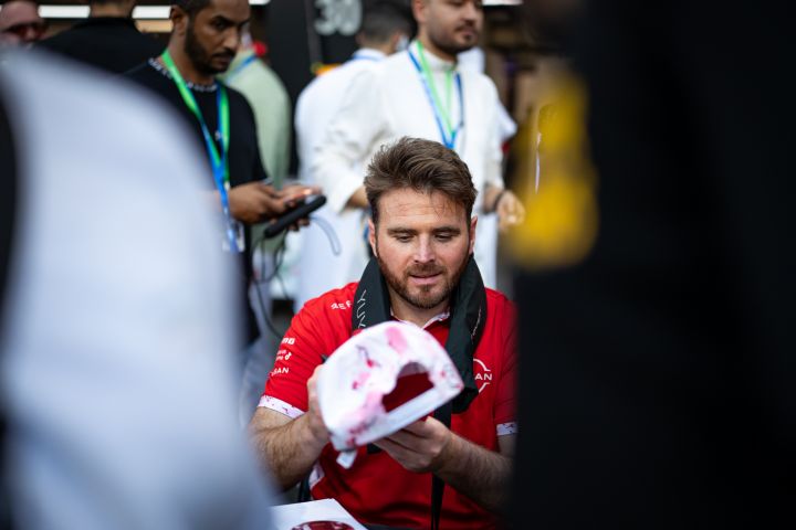 Oliver Rowland signiert während einer Autogrammstunde in Dschidda eine Kappe für einen Fan