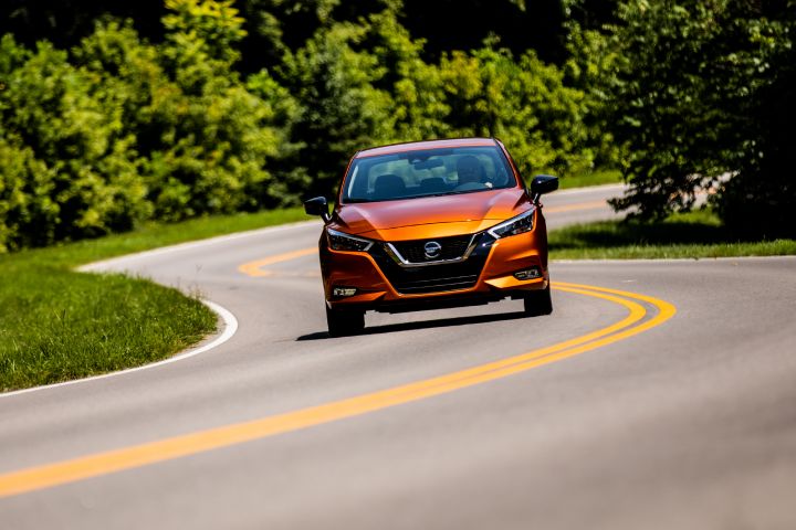 An orange 2021 Nissan Versa driving on the road