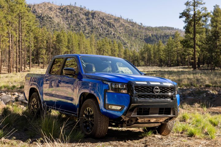 Front right 3/4 view of the 2027 Nissan Frontier Sport Edition parked on a clearing in a wooded area.