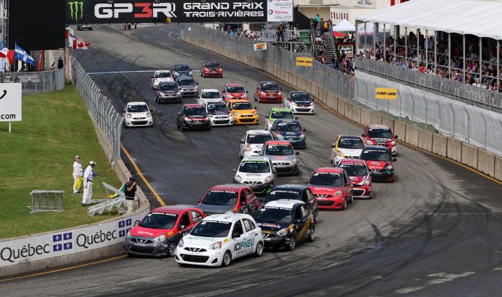 A big group of Nissan Micra entering a turn during the race