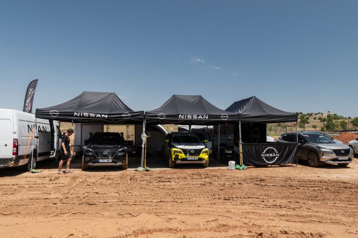 Nissan Area bei der Baja Aragon Rallye 2024, bestehend aus mehreren Nissan Pavillons, zwei serienmäßigen nissan X‑Trail und einem Nissan X‑Trail Rennwagen