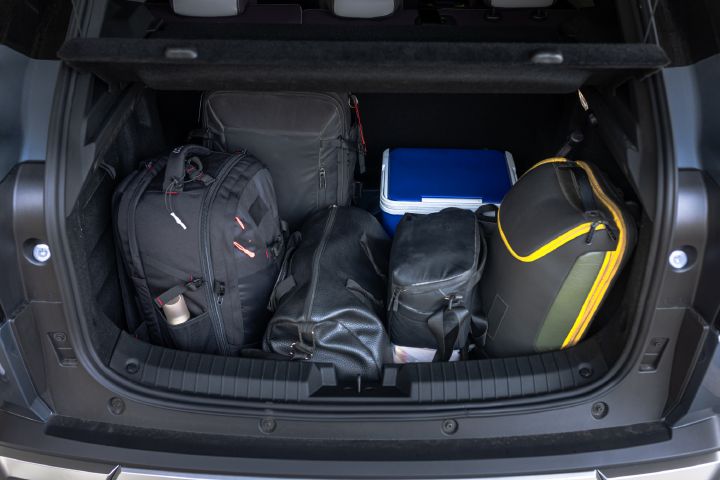 Rear trunk of Tekton viewed from the back, with bags and a cooler neatly arranged side by side.