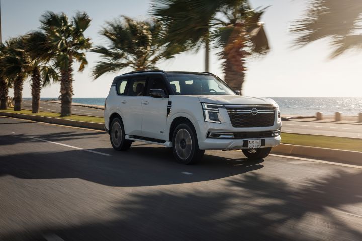 Front ¾ dynamic image of a Y63 Nissan Patrol driving down a road near a beach.