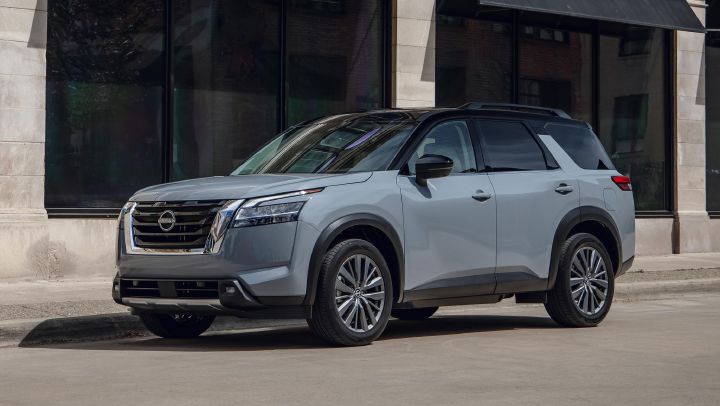 A Nissan SUV is parked outside a building.