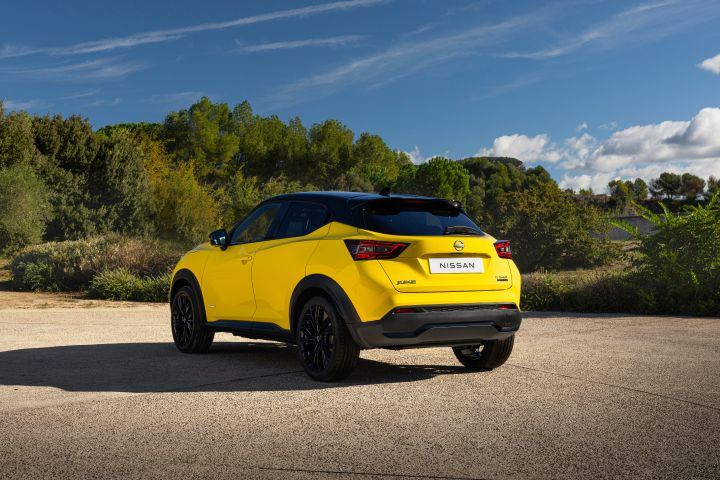 Gelber Nissan Juke 3/4 Heck auf hellem Untergrund vor Wiese