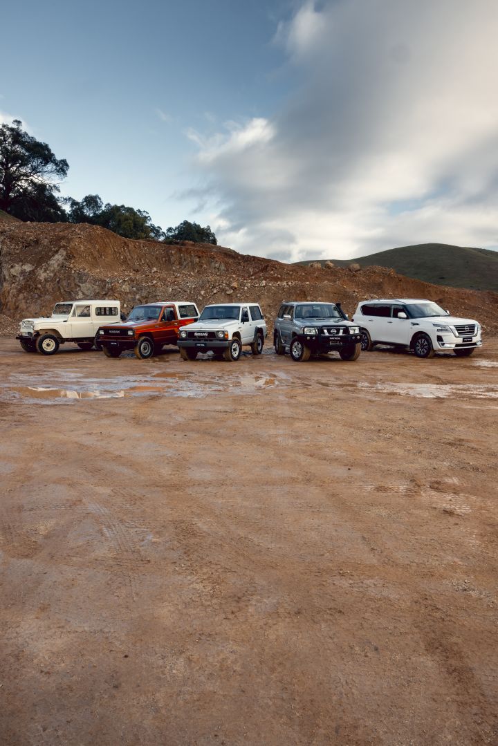 Nissan Patrol generations finished in various colours static group exterior lineup on muddy off-road terrain with rolling hills and cloudy sky