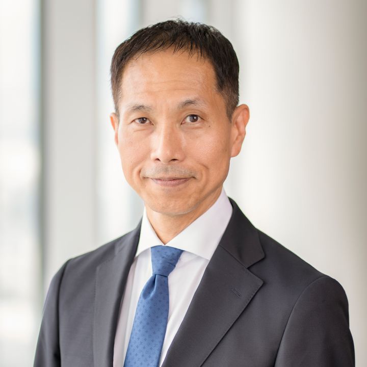 Portrait of Toru Ihara with navy blue suit, tie and NISSAN corporate pin (smiling)