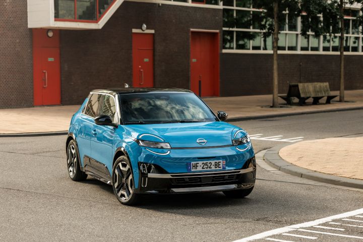3/4-Frontansicht eines blauen Nissan Micra, der an einer Kreuzung links abbiegt