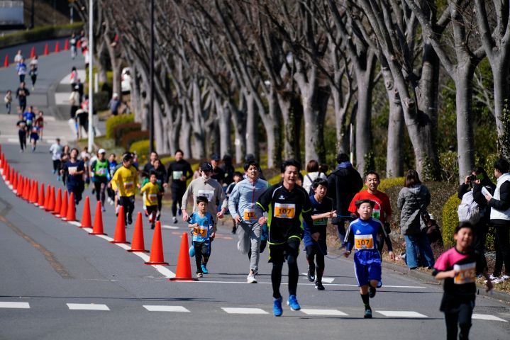日産テクニカルセンターの道路を走り抜けるランナーたち