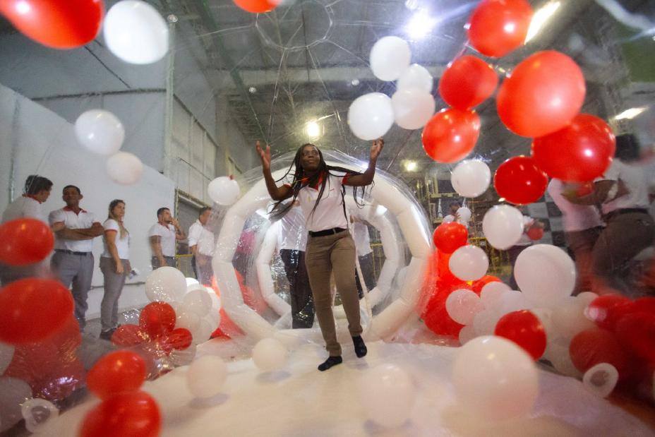 Funcionária da Nissan do Brasil, caminhando por um túnel colorido