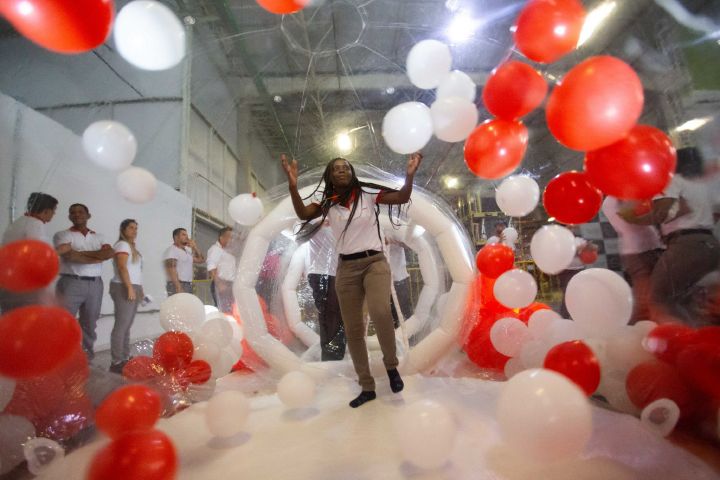 Funcionária da Nissan do Brasil, caminhando por um túnel colorido