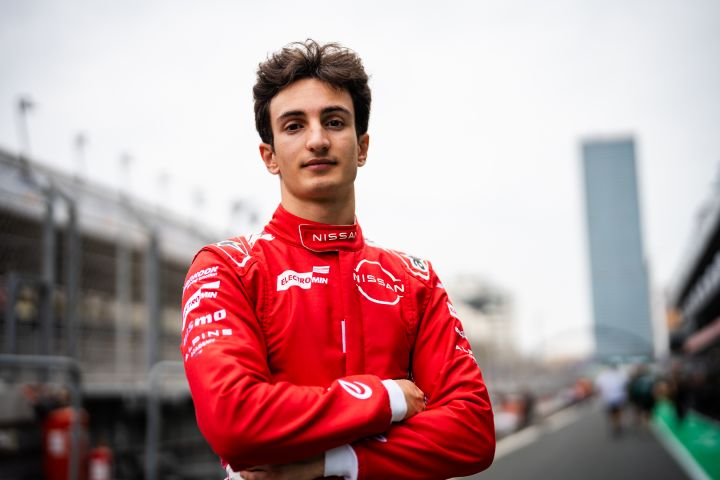 Querformat-Halbporträt von Gabriele Minì in seinem roten Nissan Formula E Team-Rennanzug mit verschränkten Armen in der Boxengasse von Jeddah.