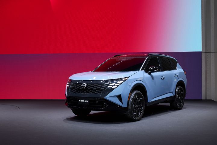 Front left 3/4 view of the 2027 Nissan Rogue Hybrid e‑POWER in front of a red gradient backgorund.