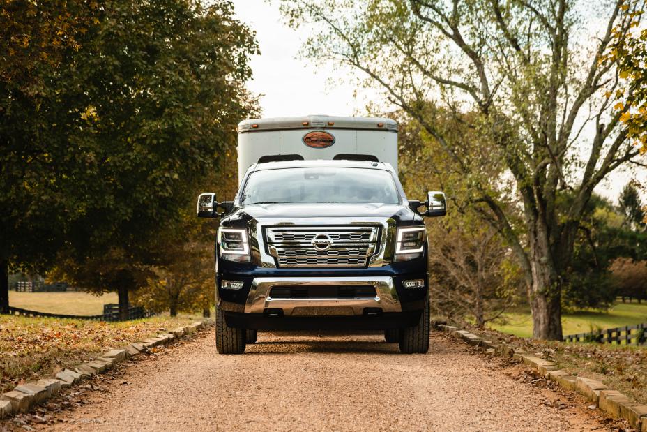 A navy blue  Nissan Titan XD SL-19 sits on a dirt road looking forward.