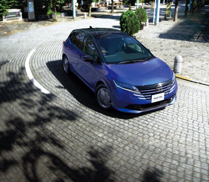 A blue Note e‑POWER running on cobblestones