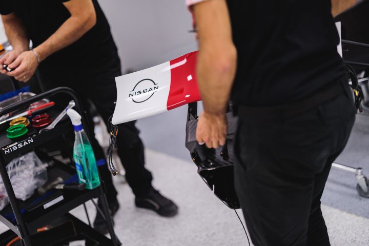 Nahaufnahme Heckflügel Nissan Formel E Rennbolide mit zwei Mechanikern