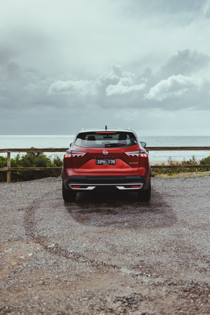 The rear of a 2026 Qashqai e‑POWER facing the sea.