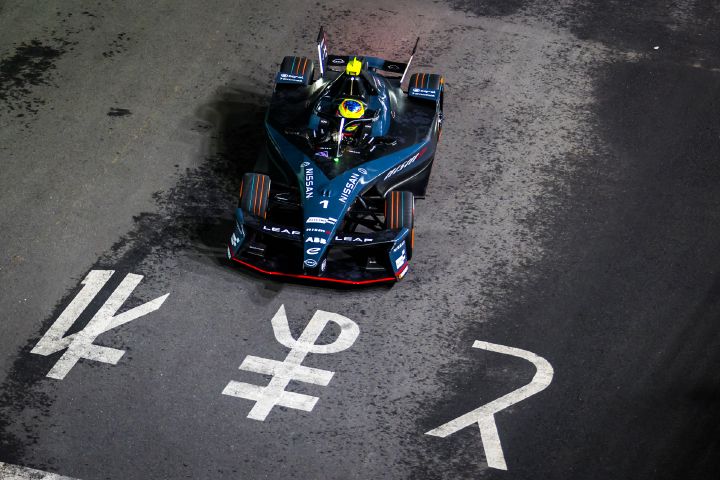 Luftaufnahme von Oliver Rowland auf der Rennstrecke im Nissan e‑4ORCE 05 mit der Startnummer 1 während des Tokyo-E-Prix-Wochenendes, mit japanischen Schriftzügen auf der Fahrbahn.
