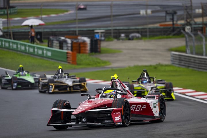 Oliver Rowland im Nissan e‑4ORCE 05 mit der Startnummer 1 biegt beim E-Prix von Shanghai nach rechts in eine Kurve ein, im Hintergrund sind mehrere Autos hinter ihm zu sehen.