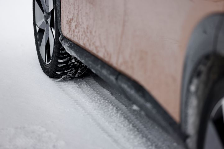 Detailansicht verschneite Flanke vom Elektroauto Nissan Ariya e‑4ORCE in Akatsuki Copper