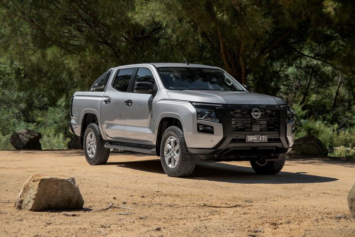 2026 Nissan Navara ST dual cab ute finished in Summit Silver photographed from the front-left three-quarter angle, featuring alloy wheels, sports bar and black grille treatment.