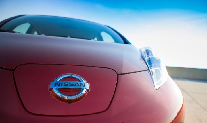 a Nissan logo on a red 2013 LEAF